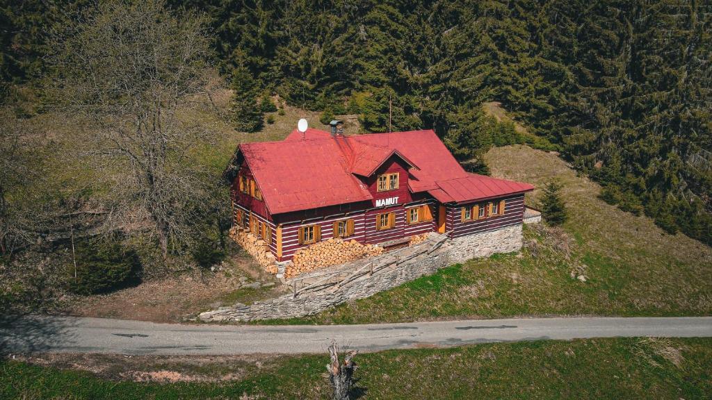 Horská chata Mamut في دولني مالا أوبا: منزل كبير مع سقف احمر على تلة
