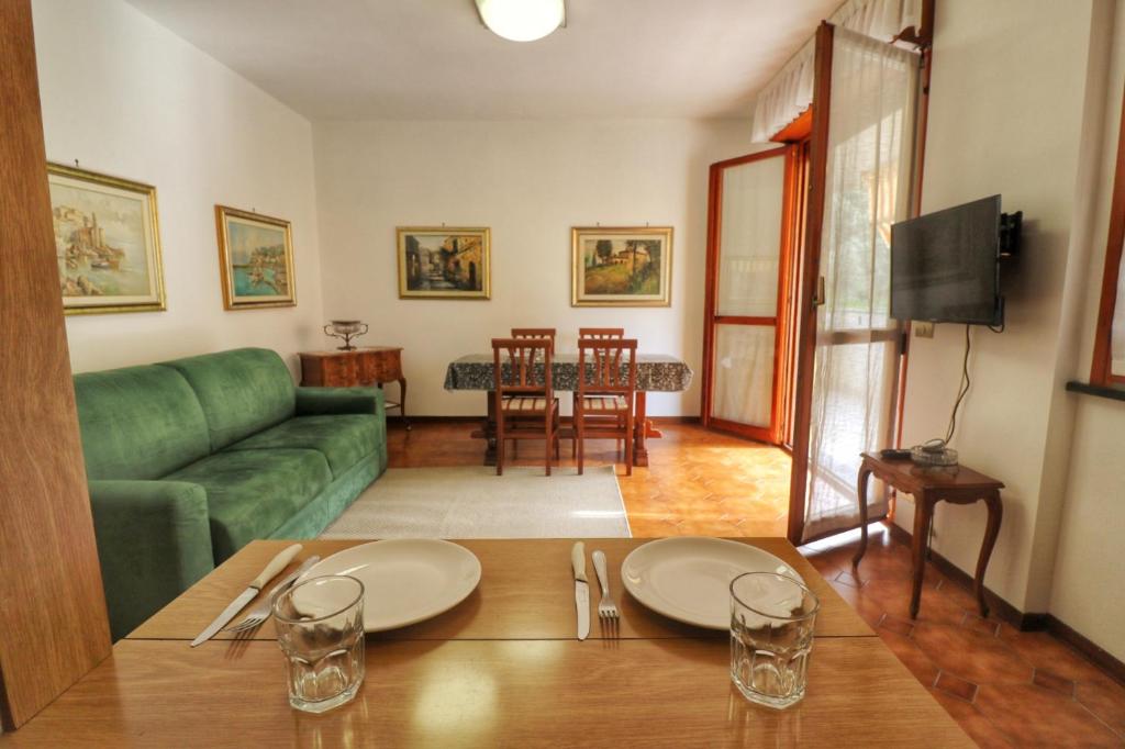 uma sala de estar com um sofá verde e uma mesa em Al Numero 4 em Levanto