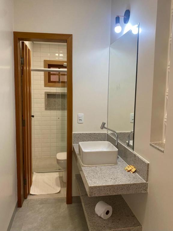a bathroom with a sink and a toilet at Pousada Mãe Natureza in Pirenópolis