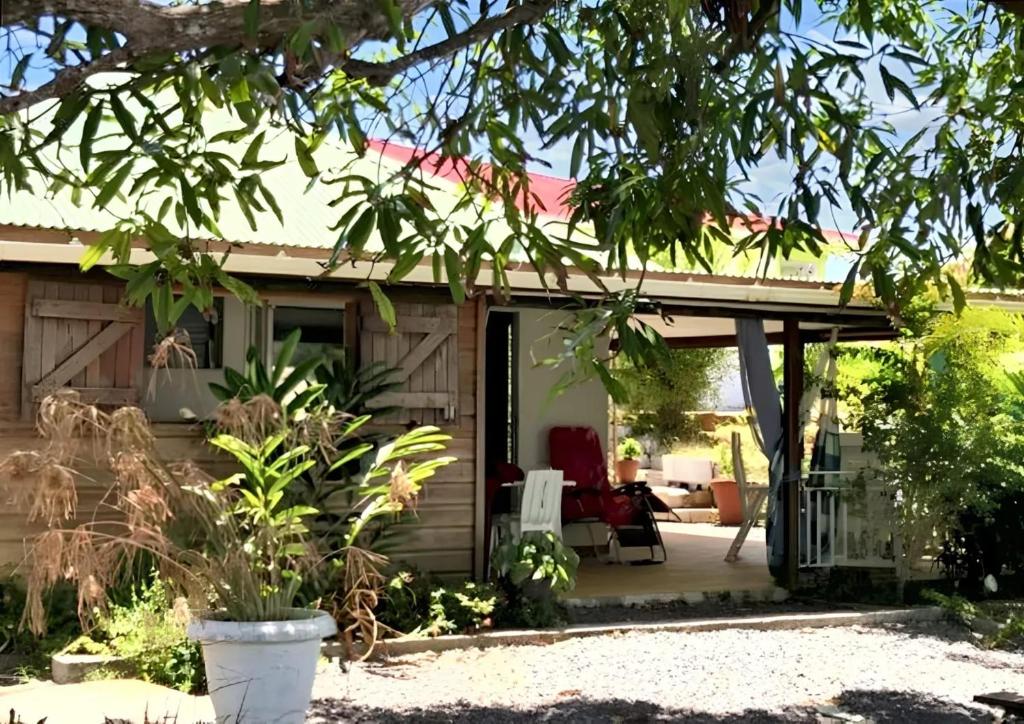 een huis met een veranda en een patio bij Studio a Sainte Anne a 350 m de la plage avec piscine partagee jardin clos et wifi in Sainte-Anne