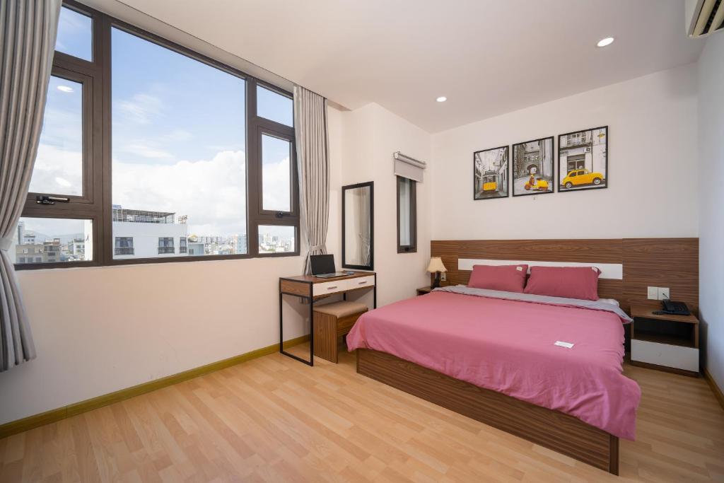 a bedroom with a bed and a large window at S HOTEL BEACH ĐÀ NẴNG in Da Nang