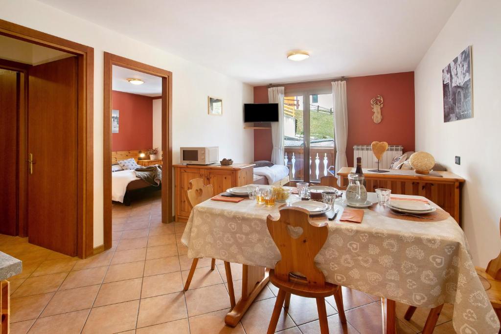 uma sala de jantar com uma mesa e uma sala de estar em Chalet Primula 11 em Santa Caterina di Valfurva