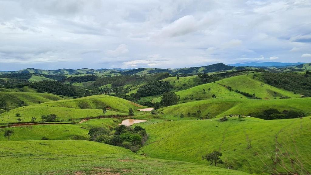 uma vista para uma encosta verde com uma estrada de terra batida em Chalé na Montanha em Cunha