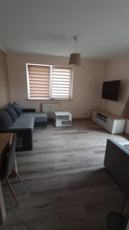 a living room with a couch and a tv at Odkryta Warszawa! - Private studio balcony, free wifi, tv, parking, self check in - Warsaw North in Warsaw
