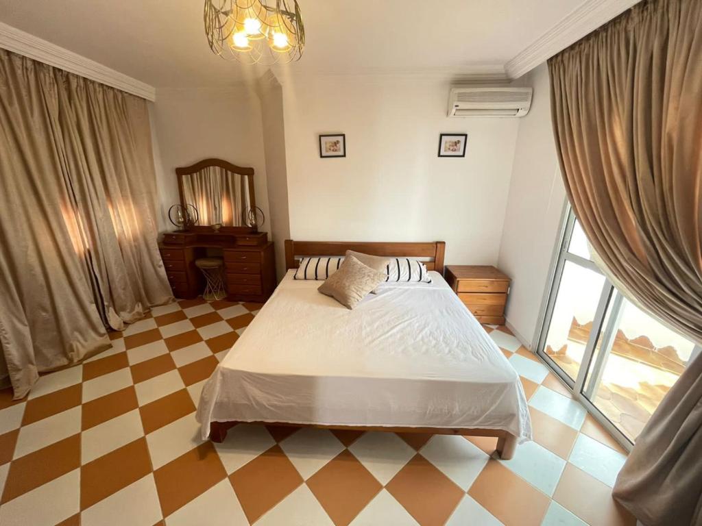 - une chambre avec un lit et un sol en damier dans l'établissement Villa Marina Smir avec piscine, à Tetouan