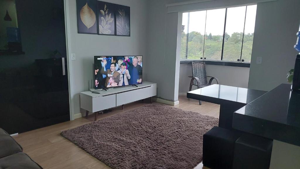 ein Wohnzimmer mit einem Flachbild-TV auf einem Schrank in der Unterkunft Apartamento bom descanso in Serra Negra