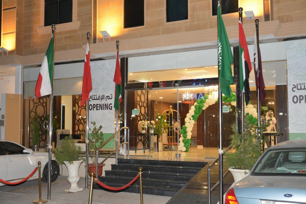 um edifício com bandeiras em frente a uma loja em Open Hotel Alolaya em Al Khobar
