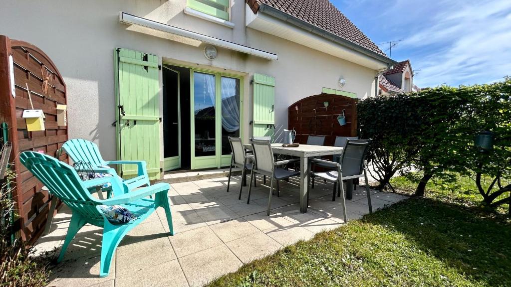 un patio avec des chaises et une table devant une maison dans l'établissement La Villa Myla, au Crotoy