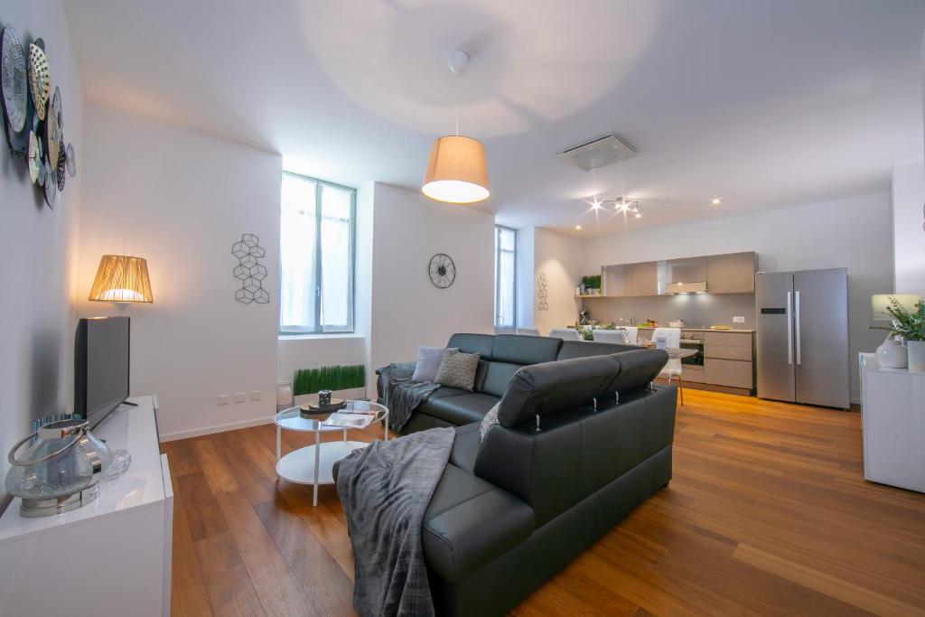ein Wohnzimmer mit einem Sofa und einer Küche in der Unterkunft Star of Lugano in Lugano