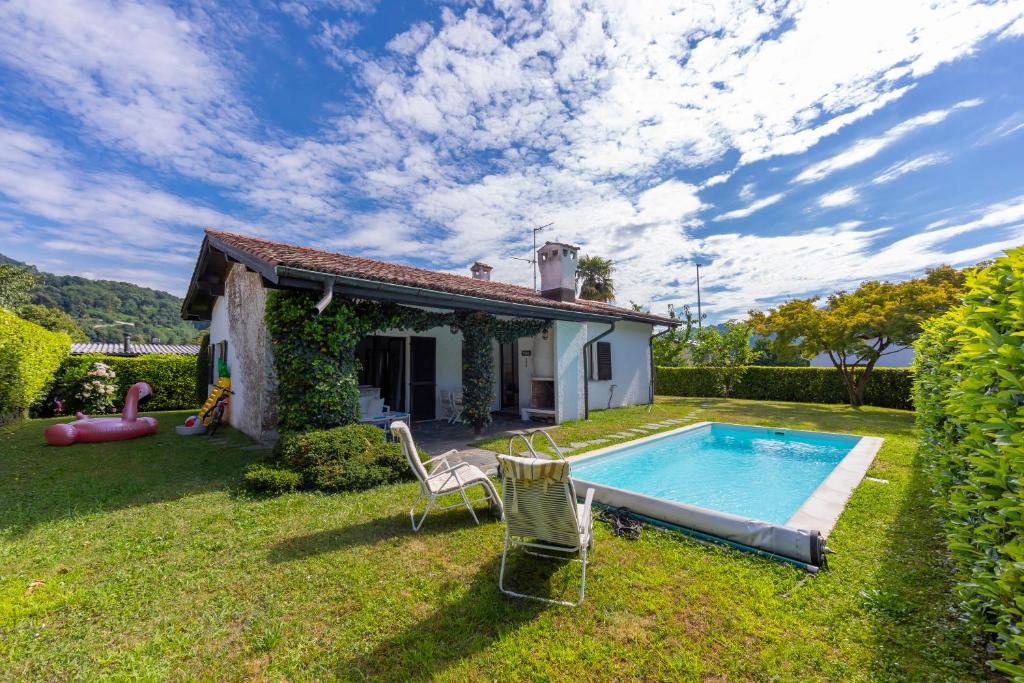 a small house with a swimming pool in the yard at Villa Calella - Happy Rentals in Magliaso