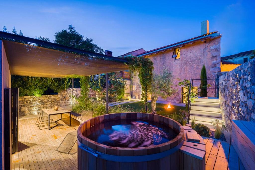 patio trasero con bañera de hidromasaje en Villa Kambra With Whirlpool, en Dutovlje
