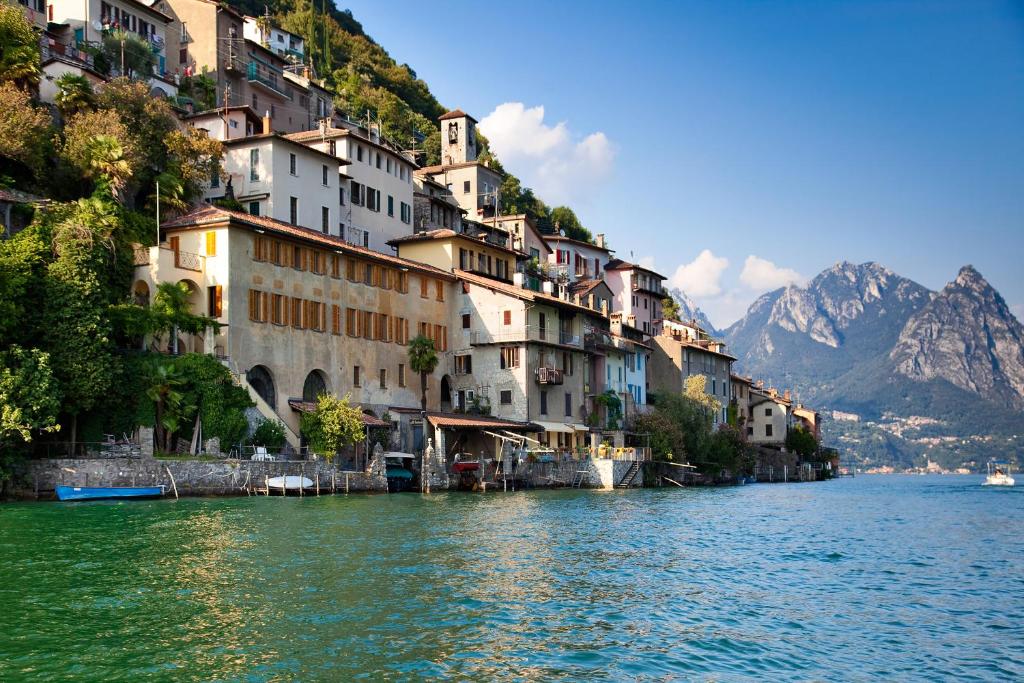 a group of buildings on a hill next to a body of water at Love of Lugano - Happy Rentals in Lugano