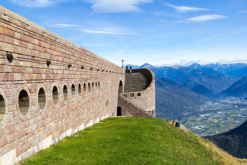 a wall on a hill with a view of mountains at Love of Lugano - Happy Rentals in Lugano