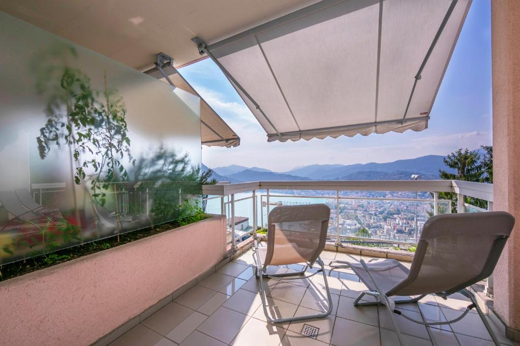 einen Balkon mit 2 Stühlen und Aussicht in der Unterkunft La Maison du Bonheur - Happy Rentals in Aldesago