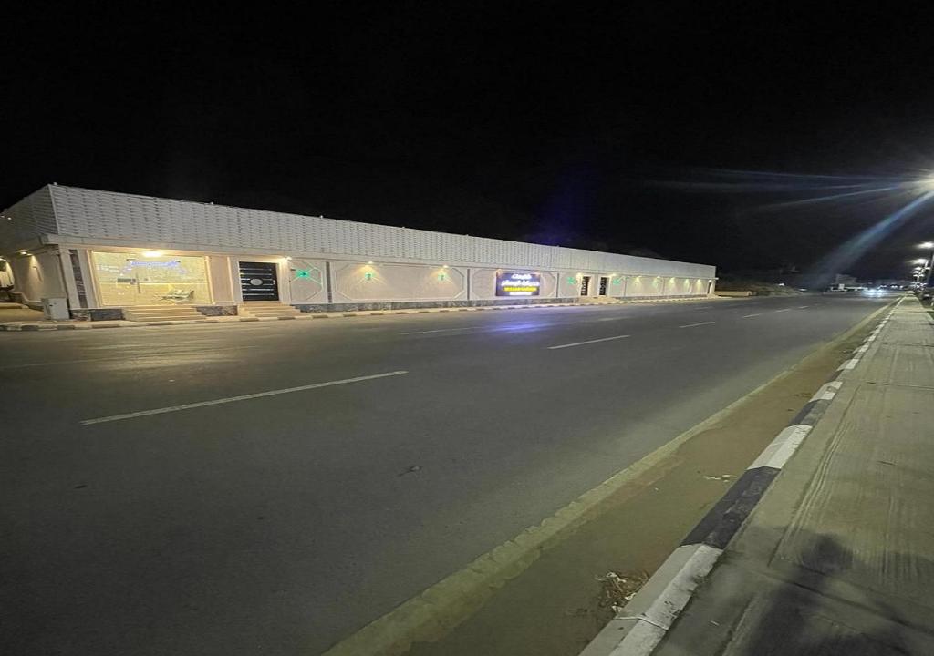 an empty street at night with a building at شاليهات حديقة الوسام in Taif