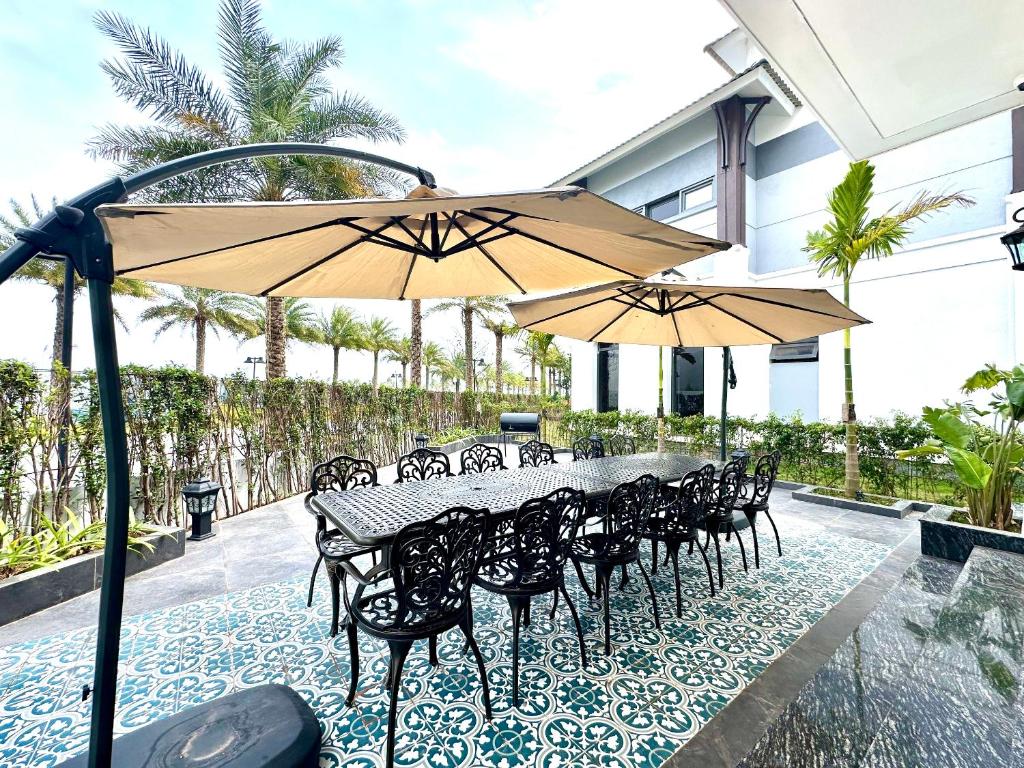 a table and chairs with umbrellas on a patio at Ký ức Đông Dương in Quang Ninh