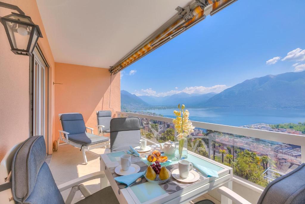 a balcony with a table and chairs and a view at Casa Monti Belvedere in Locarno