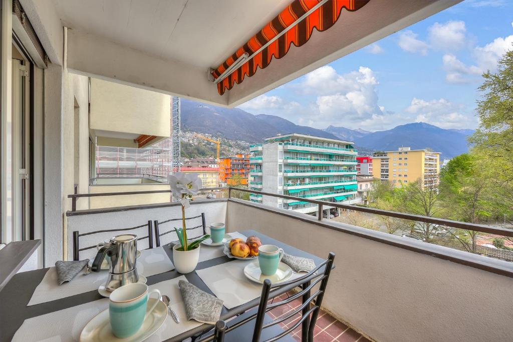 einen Tisch und Stühle auf einem Balkon mit Aussicht in der Unterkunft Lido Apartment in Locarno