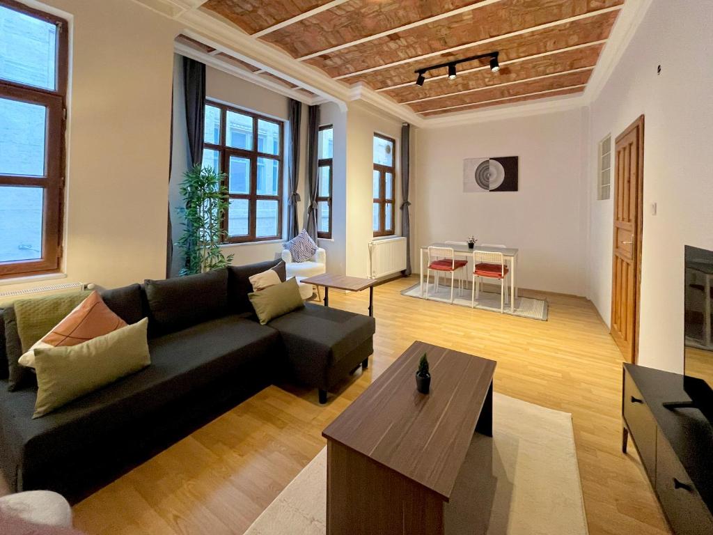 a living room with a black couch and a table at Apartment w/ New Furnitures Next to Istiklal Street and Taksim Square in Istanbul