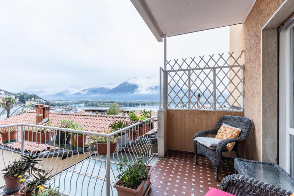 a balcony with a chair and a view of the mountains at Casa Lucia - Iseo Lake View - by HOST4U in Lovere