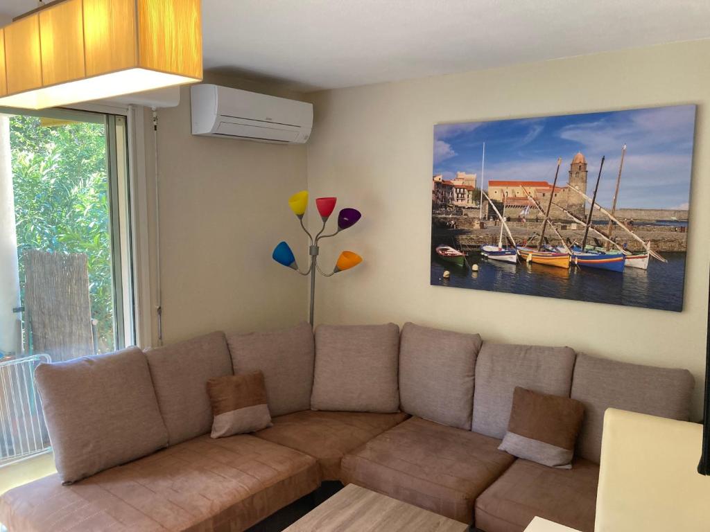 un salon avec un canapé et un tableau au mur dans l'établissement Saphir de Collioure, à Collioure