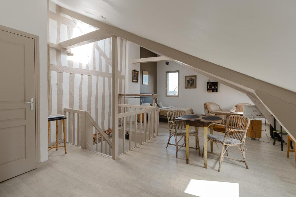 a living room with a staircase and a table and chairs at Studio et appartements Sainte Catherine in Honfleur