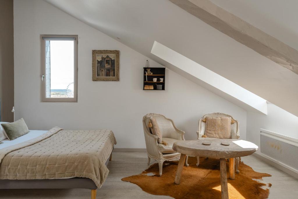 a bedroom with a bed and a table and chairs at Studio et appartements Sainte Catherine in Honfleur
