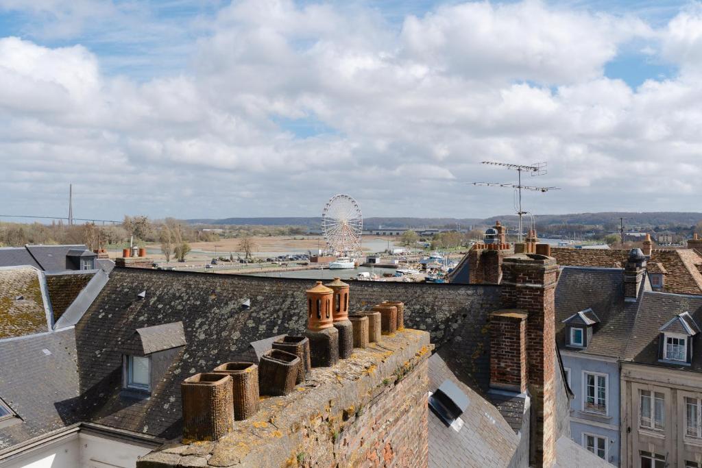 a view from the roofs of buildings with a ferris wheel at Studio et appartements Sainte Catherine in Honfleur