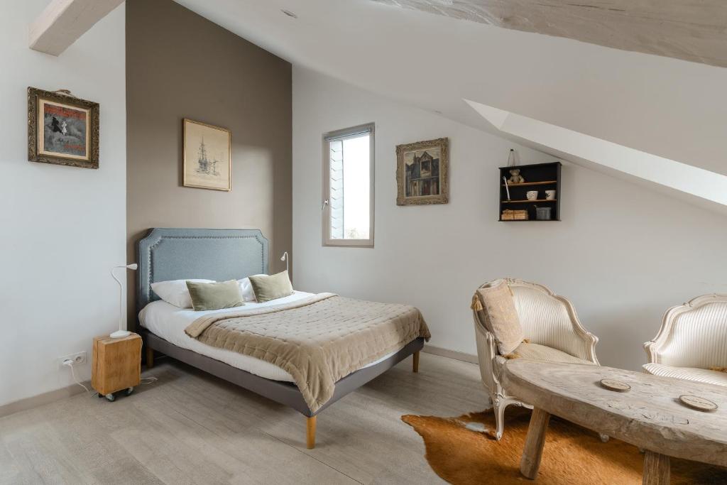 a bedroom with a bed and a table and a chair at Studio et appartements Sainte Catherine in Honfleur
