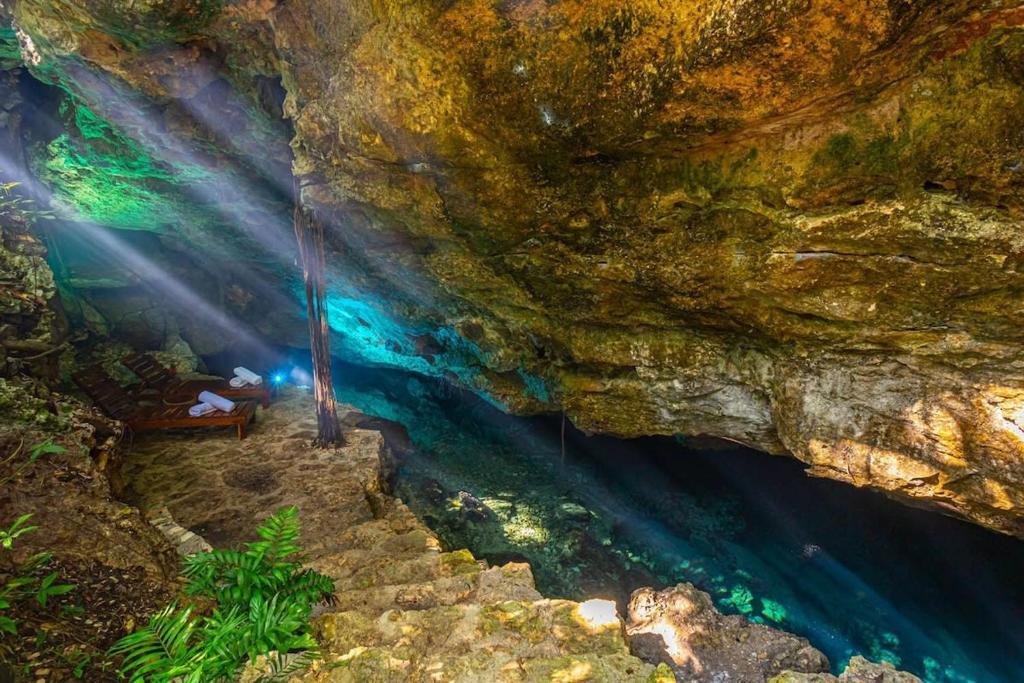 uma pessoa sentada num banco numa caverna em * Dream Villa on Private Cenote 10min to Beach em Akumal