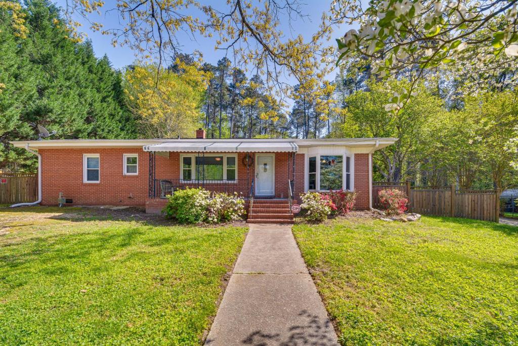 una pequeña casa de ladrillo con un patio de hierba en Raleigh Retreat about 5 Mi to Dtwn and Historic Oakwood!, en Raleigh