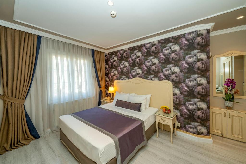 sypialnia z łóżkiem i kwiatowym malowidłem ściennym w obiekcie Raymond Hotel w Stambule