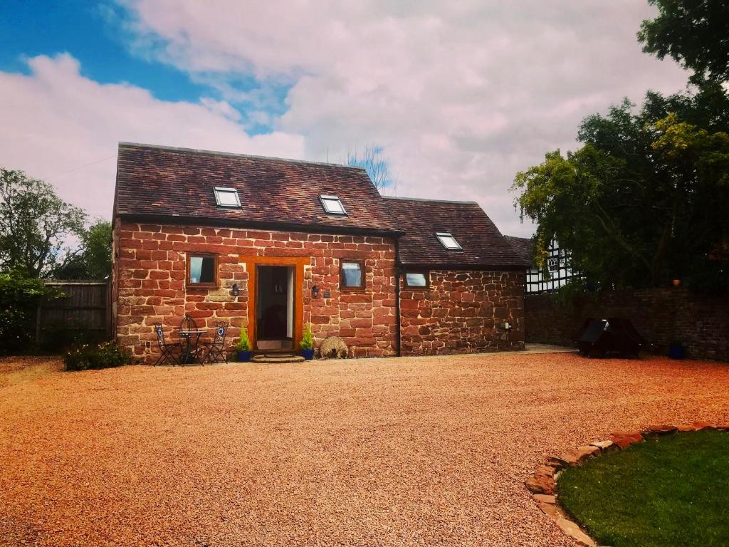 a small brick house with a gravel yard at Stone Cottage. Full of character barn conversion Pass the Keys in Highley