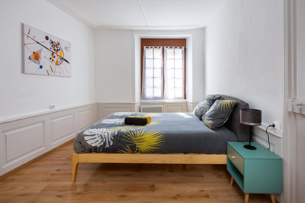 une chambre avec un lit dans une pièce blanche dans l'établissement Le Grand Franciscain - centre historique, à Mulhouse