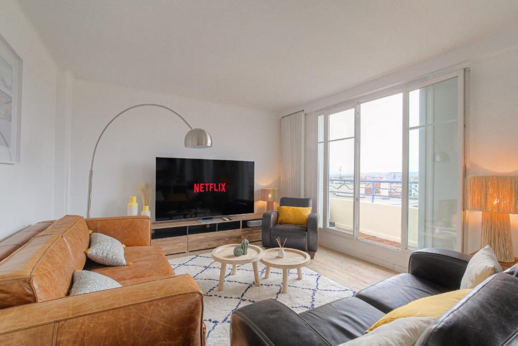 un salon avec un canapé et une télévision dans l'établissement Charmant et Chaleureux avec garage privé, à Villeurbanne