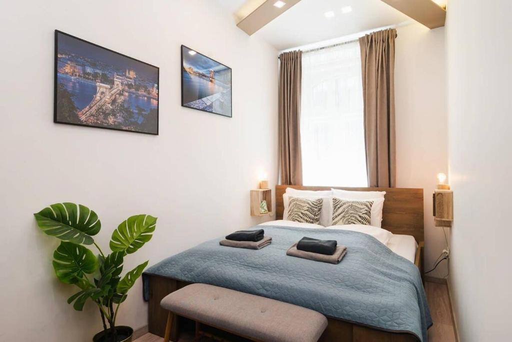 a bedroom with a bed and a plant and a window at Perfect place in the heart of downtown in Budapest