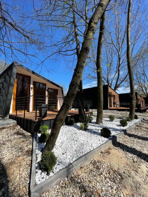 a modular home with a porch and trees at Hotel Blisku do gradot in Skopje
