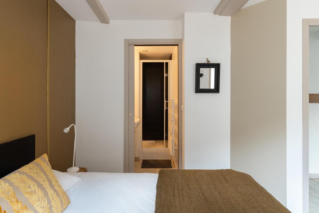 a bedroom with a bed and a door leading to a hallway at Studio et appartements Sainte Catherine in Honfleur