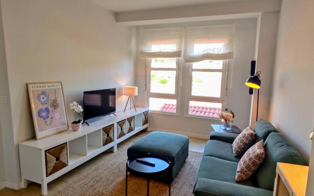 a living room with a couch and a tv at Apartamento Arcoiris in Betanzos