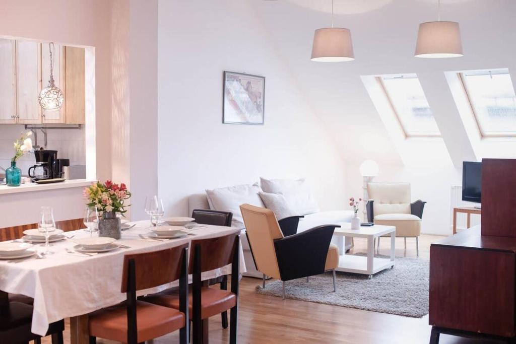 a dining room and living room with a table and chairs at Stylish and comfy apartment for 6 guests in Budapest