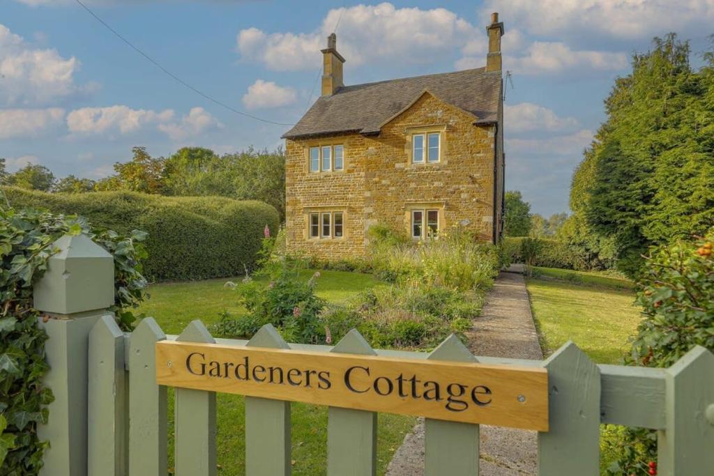 een bord op een hek voor een tuinhuisje bij Gardeners Cottage - Hot Tub Packages Available in Market Harborough