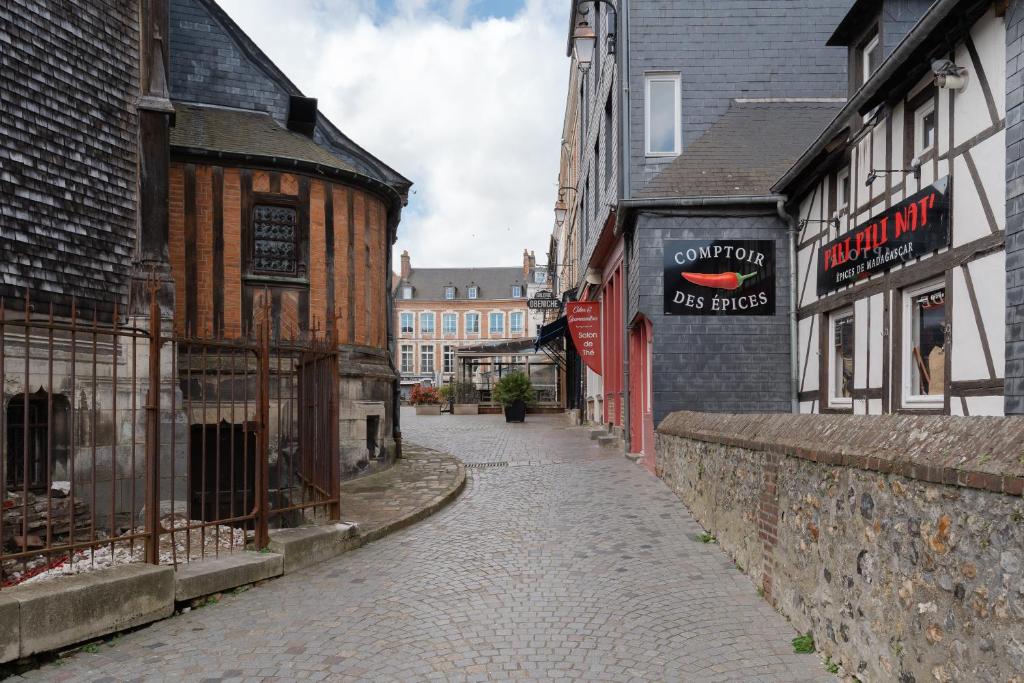 a cobblestone street in an old town with buildings at Studio et appartements Sainte Catherine in Honfleur