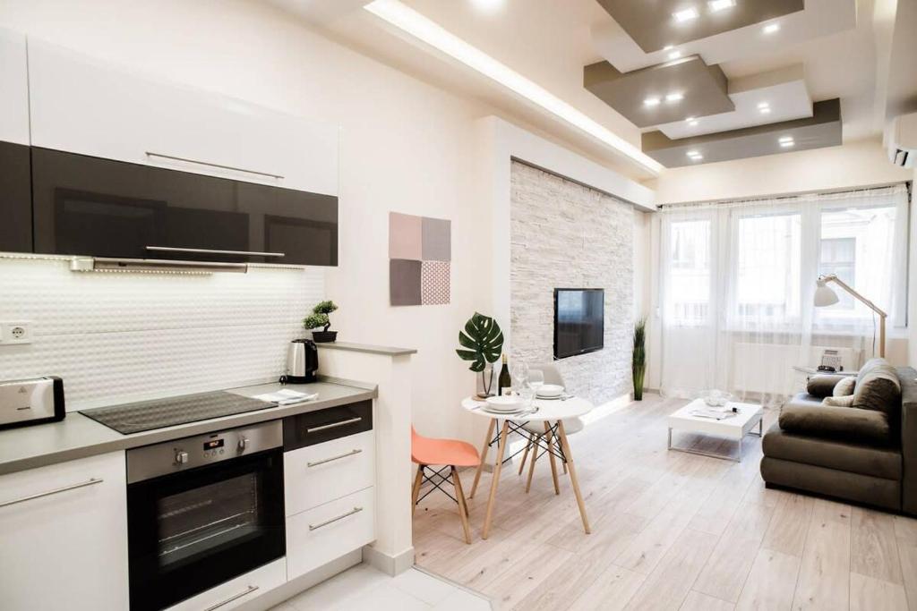 ブダペストにあるNew luxury apartment in the center with A/Cのキッチン、リビングルーム(ソファ、テーブル付)