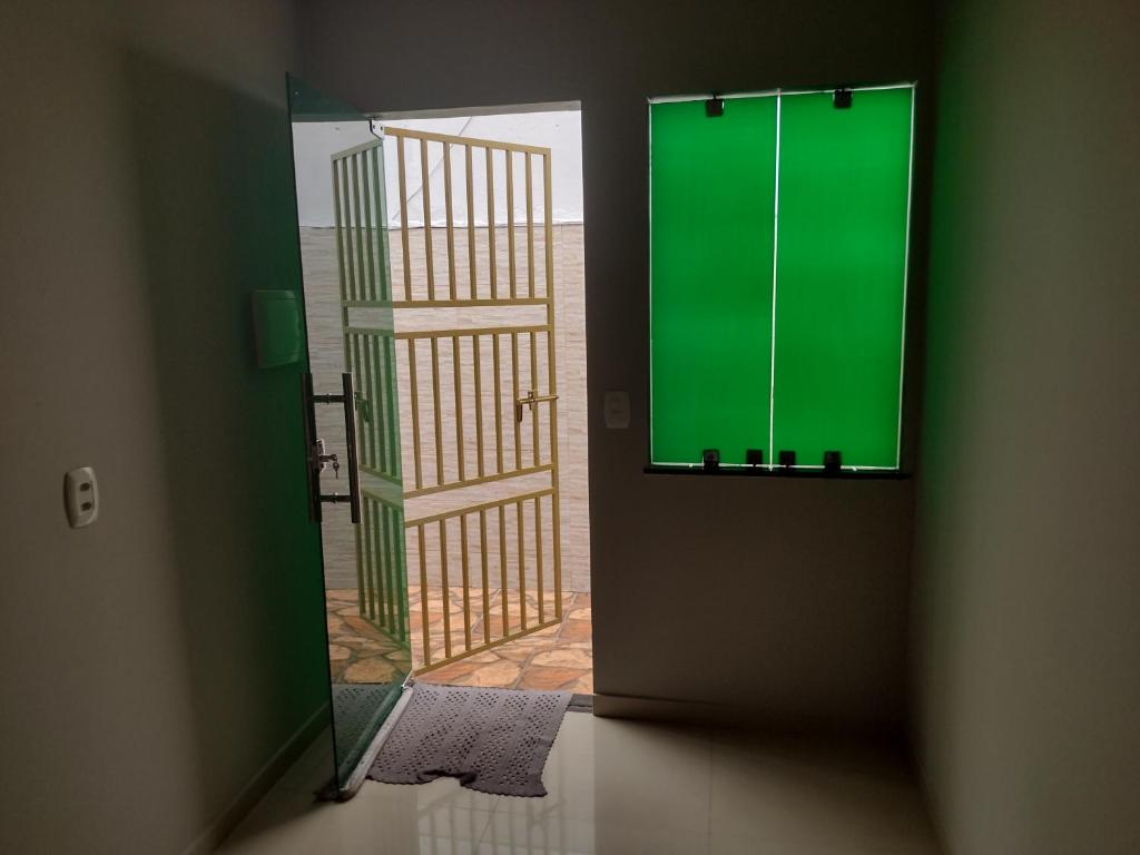 une porte avec une fenêtre verte dans une pièce dans l'établissement Kitnet mobiliado, à Belém