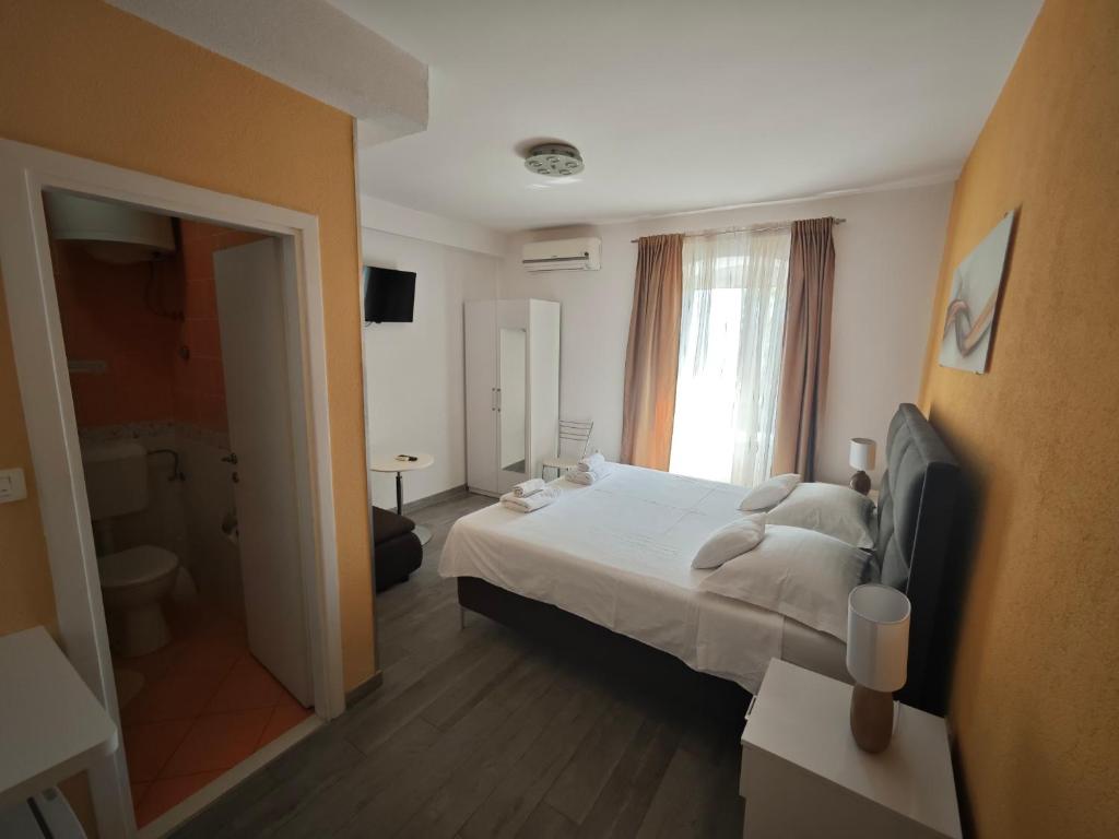 a hotel room with a bed and a bathroom at Nirvana Rooms & Apartments in Split