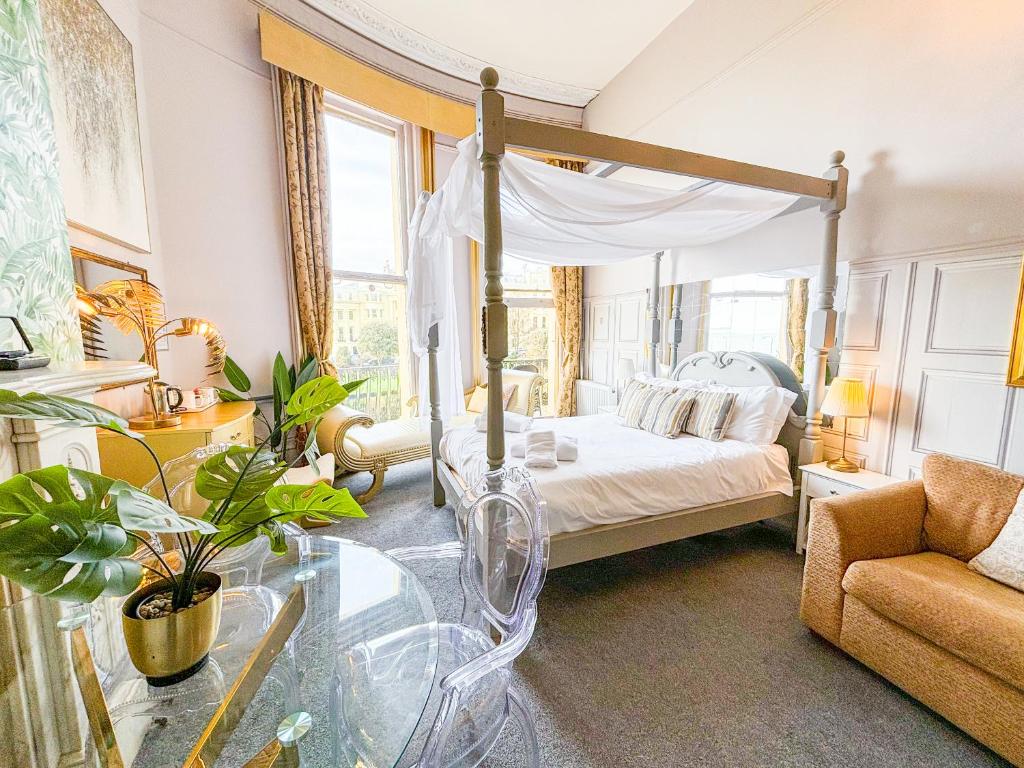 a bedroom with a canopy bed and a glass table at X Hotel Brunswick Square in Brighton & Hove