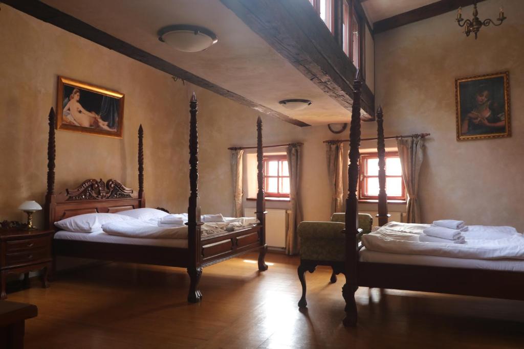 a bedroom with two beds and two windows at Penzion Baroko in Český Krumlov