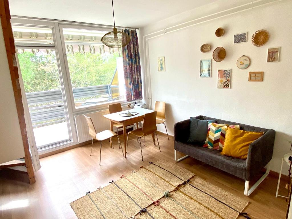 uma sala de estar com um sofá e uma mesa em Napsugár Retro Apartman em Gárdony