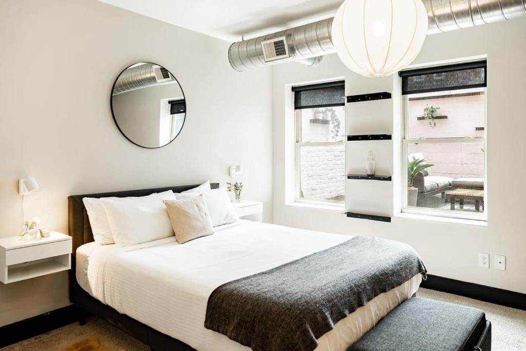 Lux Parkside 1BR - Patio - Sun Deck - Free Parking في سينسيناتي: غرفة نوم بها سرير كبير ومرآة
