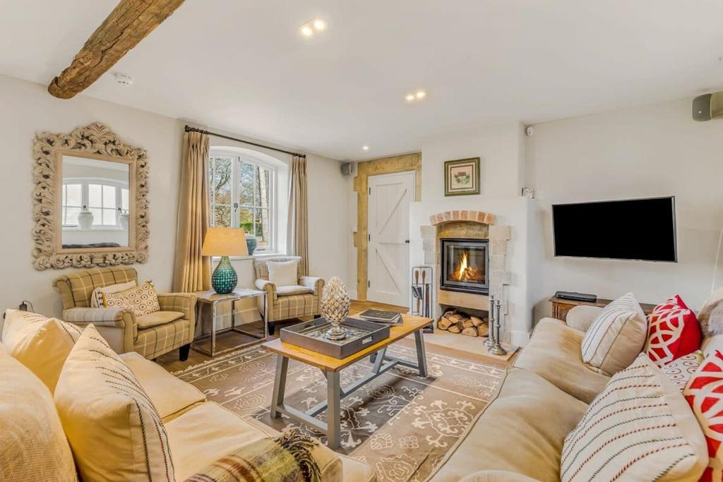 a living room with a couch and a fireplace at Washbrook Cottage - Hot Tub Packages Available in Little Compton